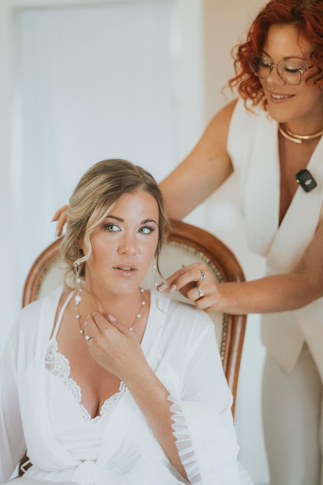 Camille peaufine la coiffure de la mariée avant la cérémonie, chignon souple et bijoux de tête